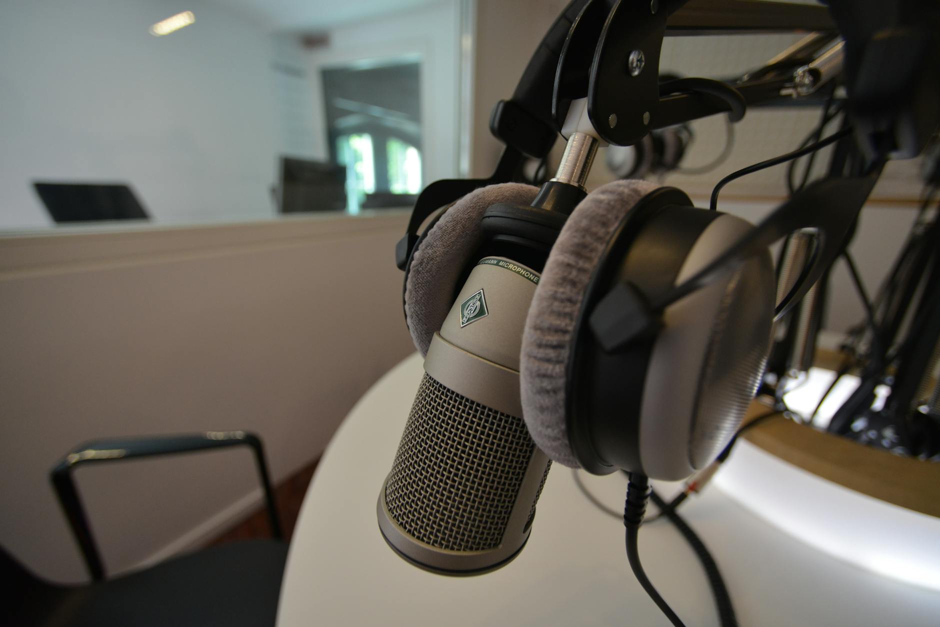 Studio podcast profesional modern dengan mikrofon berkualitas tinggi, siap merekam audio jernih.